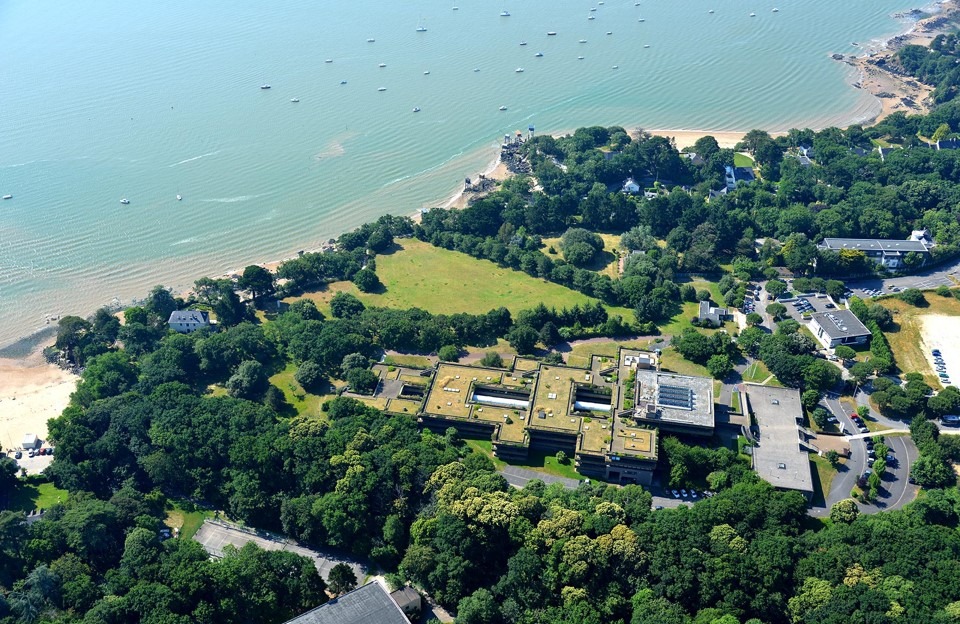 L'image montre la côte de Saint NAzaire, avec la mer à gauche et la terre à droite, avec beaucoup d'arbres et quelques infrastructures