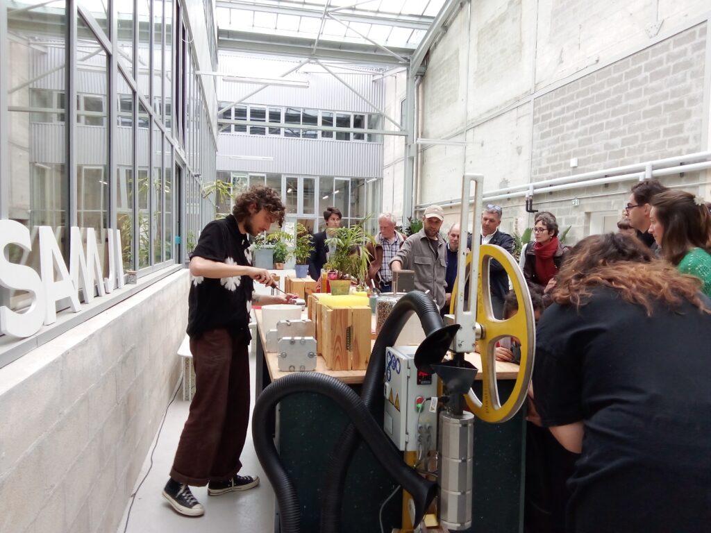L'image montre un atelier avec une personne construisant des objets à parir de plastique recyclé